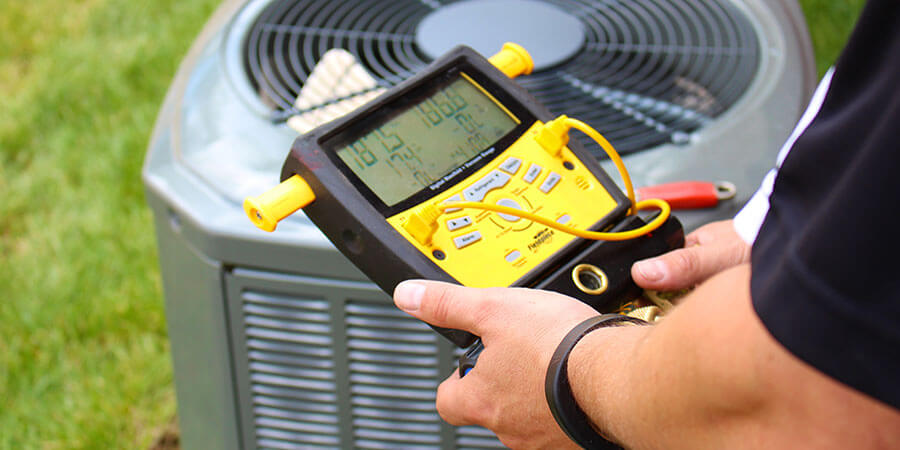 Technician with tools in hand checking AC unit